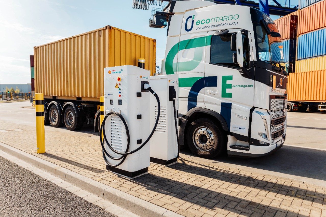 Ein E-Lkw - beladen mit einem Container - steht an einer Ladesäule.