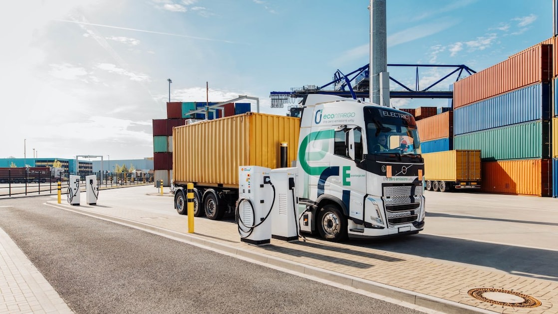 Ein E-Lkw - beladen mit einem Container - steht an einer Ladesäule.