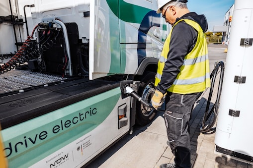Ein Mann steckt seinen E-Lkw an.