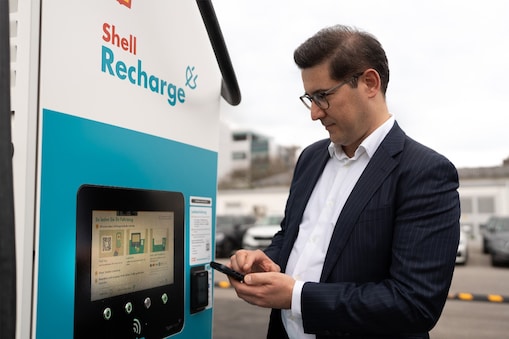 Ein Mann startet den Ladevorgang an einer Shell Recharge Ladesäule.