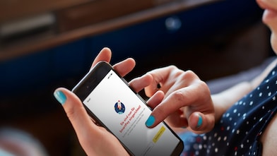 Frau hält Smartphone mit geöffneter Shell App und Shell SmartPay in der Hand