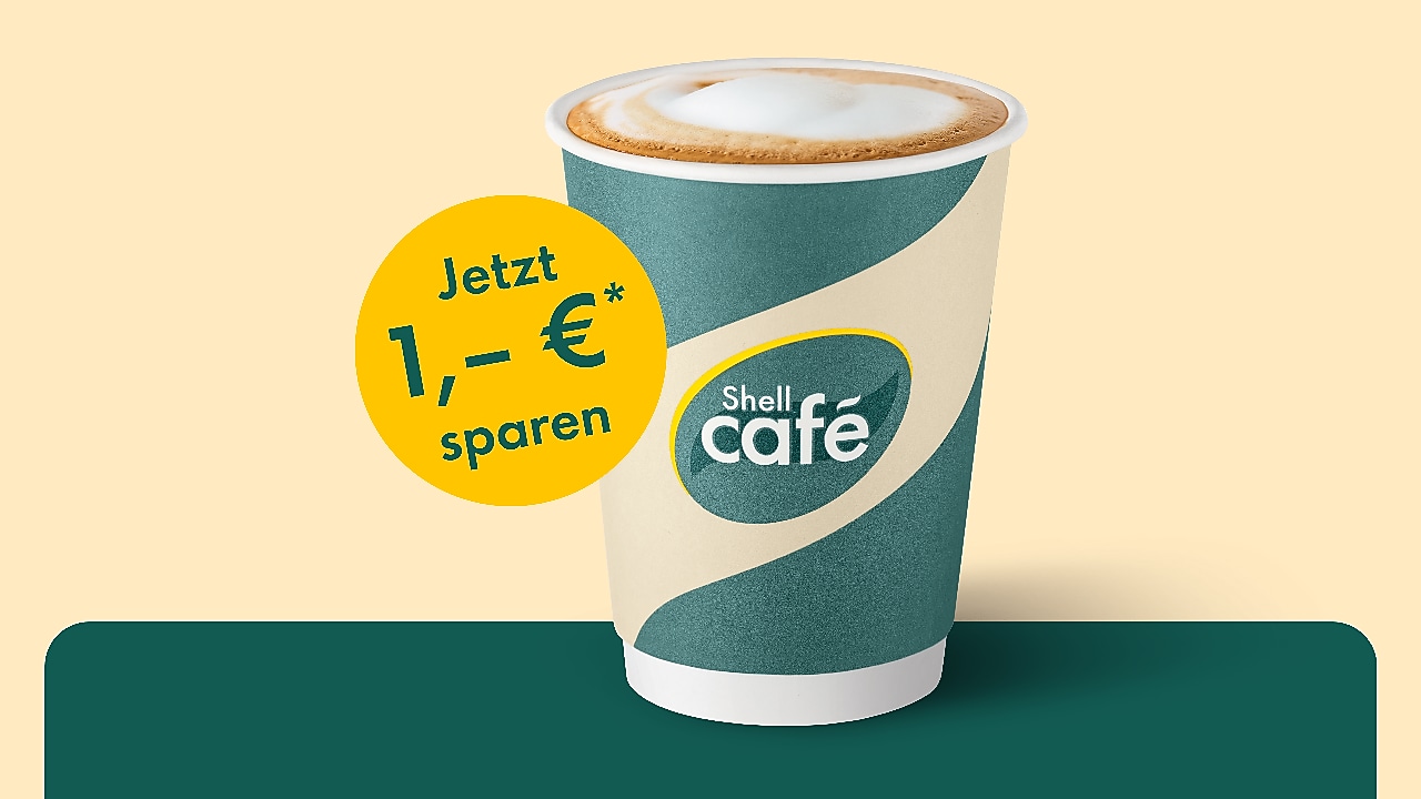 Junge Frau hält lächelnd den Ladestecker einer Shell Recharge Ultraschnellladesäule in der Hand.