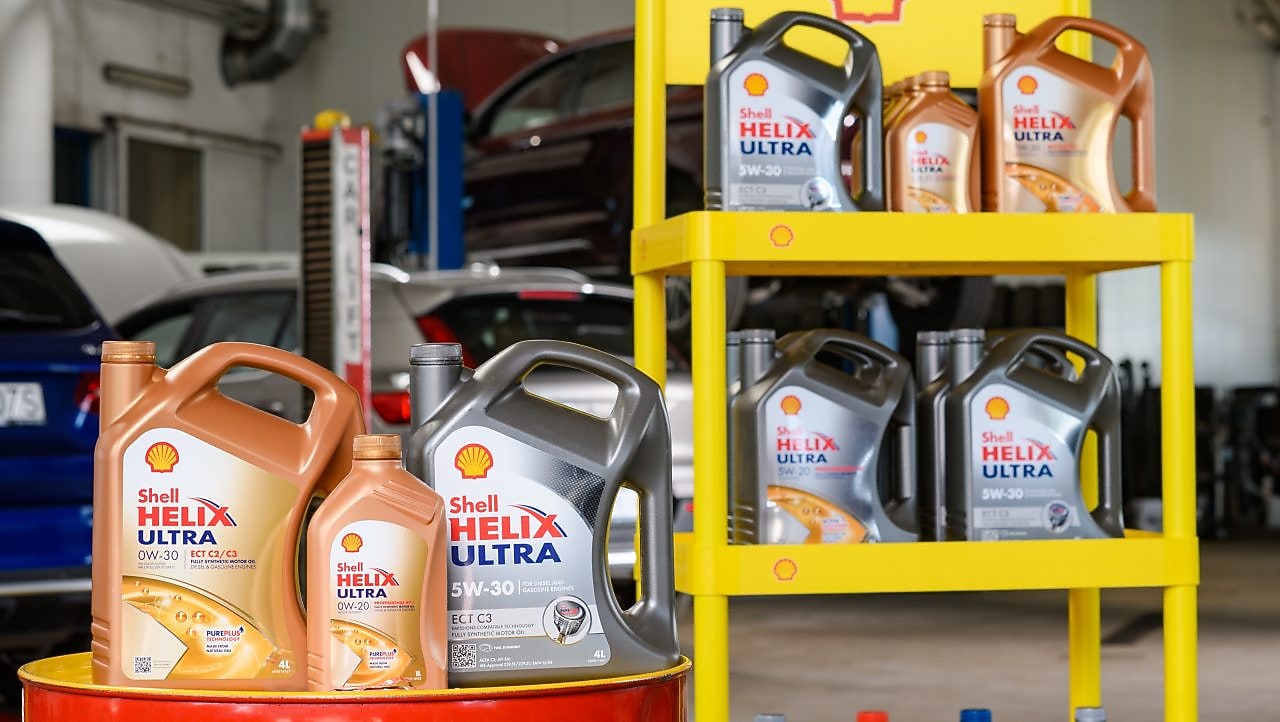 Shell Helix Ultra Motorölkanister in verschiedenen Viskositäten auf Werkstattregal – synthetische Premium‑Motoröle für Pkw, entwickelt für höchste Effizienz und Motorsauberkeit