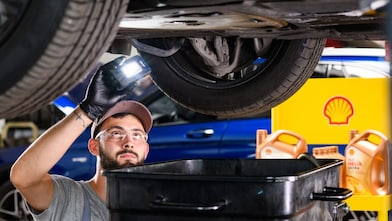 Motorölwechsel in der Werkstatt: Fachkraft füllt Shell Helix Ultra Motoröl in den Motor eines Pkw – optimale Schmierung, Motorschutz und Leistungsfähigkeit durch hochwertige Shell Schmierstoffe.