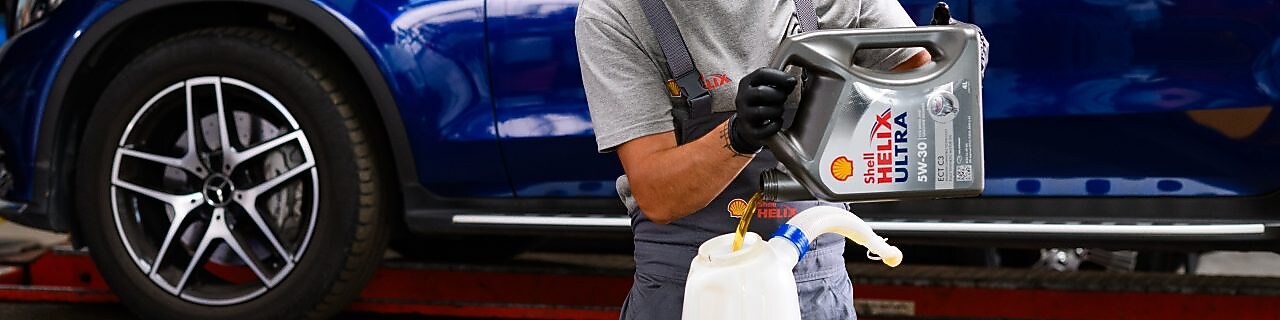 A person wearing a grey shirt and black gloves