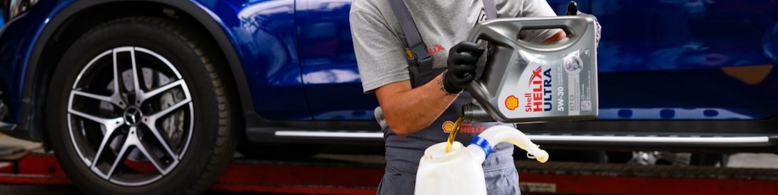 A person wearing a grey shirt and black gloves