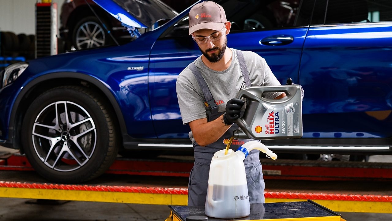 A person wearing a grey shirt and black gloves