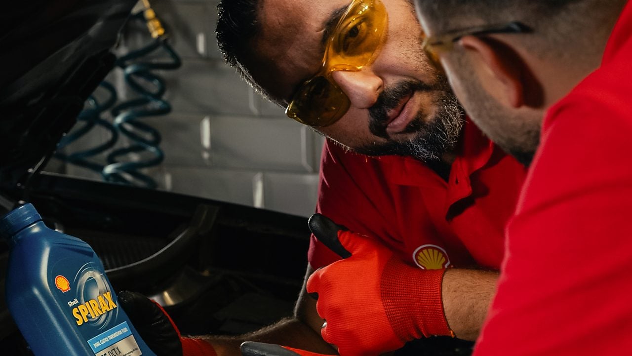 Mechaniker bei der Wartung eines Fahrzeugs im Motorraum, Anwendung von hochwertigen Schmierstoffen zur optimalen Motorleistung