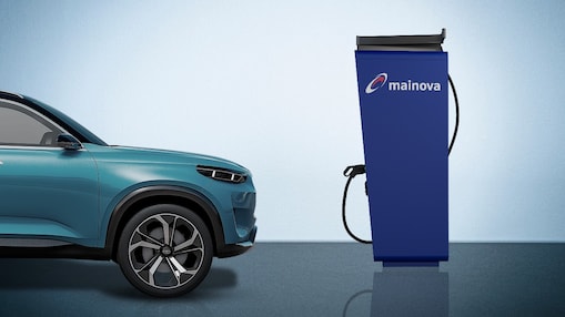 Ein graublaues Auto fährt von links ins Bild und auf der rechten Seite ist eine blaue Mainova Ladesäule  zu sehen