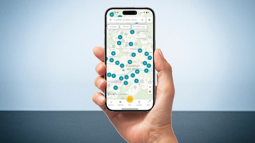 Eine Hand, die ein Smartphone hält und auf dem Shell Ladepunkte zu sehen sind.