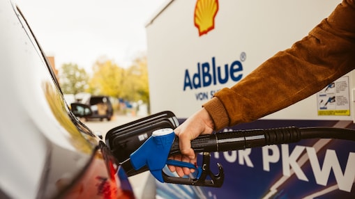 Ein Mann füllt das AdBlue seines Fahrzeugs über eine Zapfpistole nach
