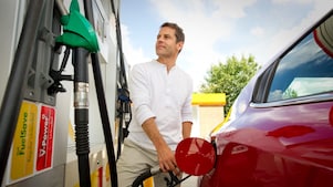 Mann mit Auto vor Zapfsäule an Shell Station