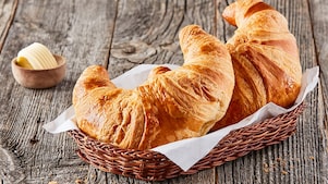 Crossaints im Körbchen auf Holztisch