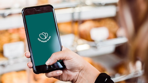 Eine Person, die die Too Good To Go App auf dem Smartphone öffnet.