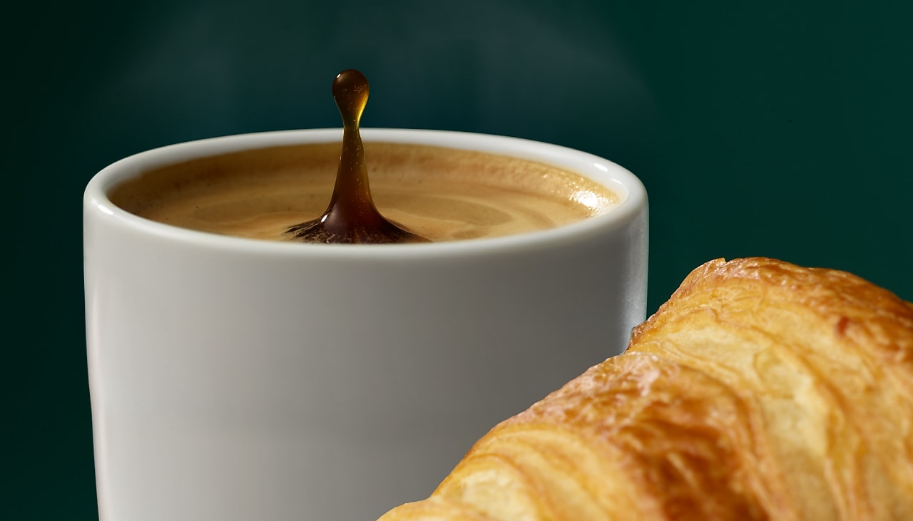 Eine Tasse Kaffee mit einem Croissant